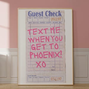 Puede incluir: Un cheque de restaurante de estilo vintage con el texto "TEXT ME WHEN YOU GET TO PHOENIX! XO" escrito en rosa sobre un fondo blanco.