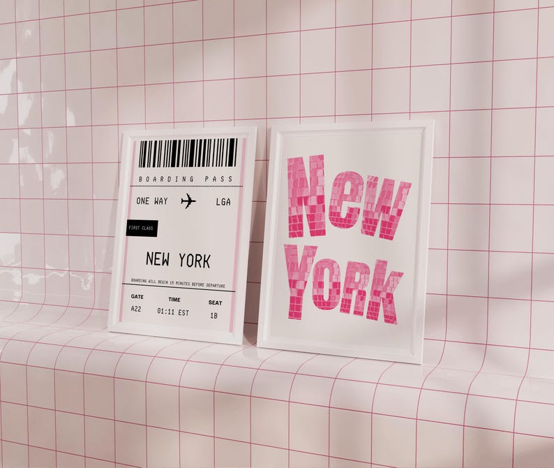 Pode incluir: Duas impress&otilde;es emolduradas brancas em uma parede de azulejos rosa. A impress&atilde;o da esquerda &eacute; um cart&atilde;o de embarque para um voo para Nova York, com o texto "BOARDING PASS", "ONE WAY", "LGA", "FIRST CLASS", "NEW YORK", "GATE 422", "TIME 01:11 EST", e "SEAT 18". A impress&atilde;o da direita tem a palavra "New York" em letras grandes de cor rosa.