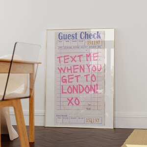 May include: A framed print of a vintage guest check with the text "TEXT ME WHEN YOU GET TO LONDON! XO" written in pink on a white background.