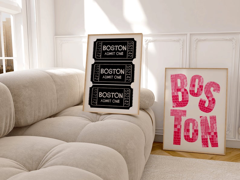 May include: Two framed prints with the word "BOSTON" in different styles. The first print features three black and white ticket stubs with the text "BOSTON" and "ADMIT ONE". The second print features the word "BOSTON" in pink mosaic tiles.