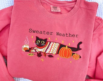 Sudadera con capucha y bordado de gato negro: colores cómodos para otoño, calabazas y hojas.