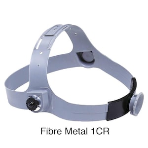 May include: A gray Fibre Metal 1CR welding helmet headgear. The headgear has a black adjustment knob, a black leatherette band, and a gray plastic frame. The text "Fibre Metal 1CR" is printed in black at the bottom of the image.