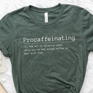 May include: A green t-shirt with the word "Procaffeinating" defined as "The art of delaying tasks until you've had enough coffee to deal with them."