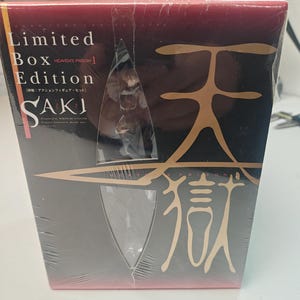 Puede incluir: Un set de figuras de acci&oacute;n SAKI de edici&oacute;n limitada en caja. La caja es principalmente negra con caracteres y texto japoneses dorados. La figura es visible a trav&eacute;s de una ventana de pl&aacute;stico transparente. La caja est&aacute; envuelta en pl&aacute;stico transparente.