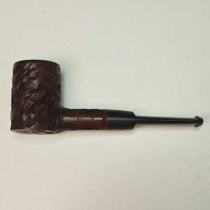 Peut inclure: Une pipe à tabac marron avec un foyer texturé et un tuyau noir. La pipe a un design classique, avec une forme incurvée et une finition lisse. Le foyer est sculpté avec un motif détaillé.