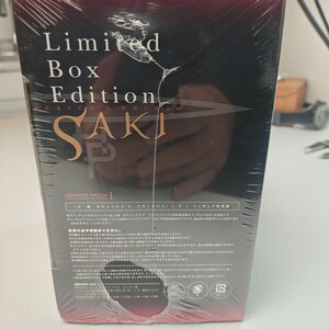 Puede incluir: Una edici&oacute;n limitada y sellada de "Heaven's Prison Saki" con texto en japon&eacute;s. La caja est&aacute; envuelta en pl&aacute;stico transparente y presenta el t&iacute;tulo en letras doradas. El fondo es oscuro con una imagen borrosa.
