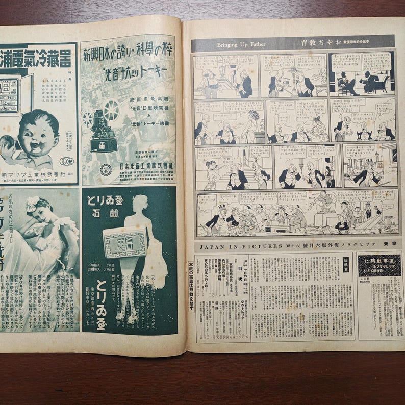 May include: An open vintage magazine featuring Japanese advertisements and a comic strip. The left side displays ads with Japanese text and illustrations, including a baby and a woman. The right side has a black and white comic strip.