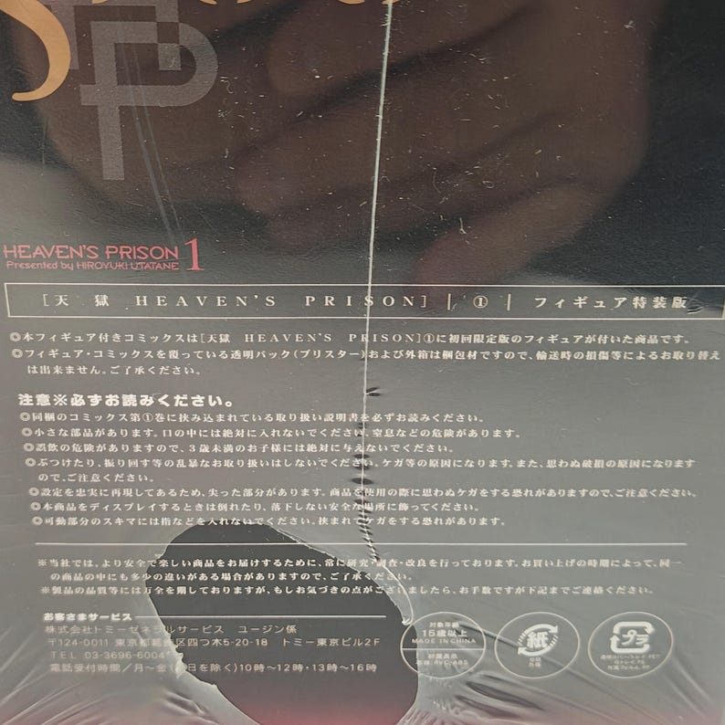 Puede incluir: Caja de producto para "HEAVEN'S PRISON 1" con texto japon&eacute;s y una figura. La caja es blanca y tiene el t&iacute;tulo en letras grandes y estilizadas. El texto incluye advertencias y detalles del producto.