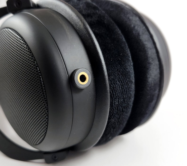 Puede incluir: Auriculares negros de diadema con un conector de audio dorado.