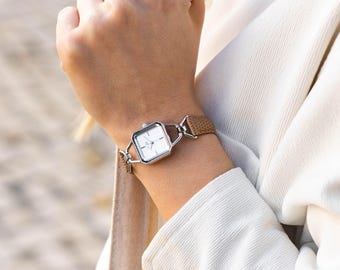 Reloj pequeño para mujer, correa de cuero marrón claro, tono plateado, forma cuadrada.