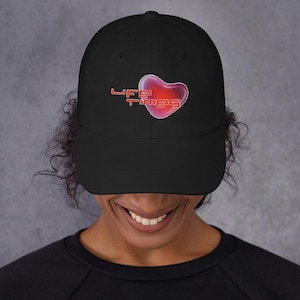 May include: Black baseball cap with a red heart and the text "LIFE TIMES" embroidered on the front.