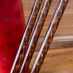 May include: Three brown and gold swirl patterned drinking straws.