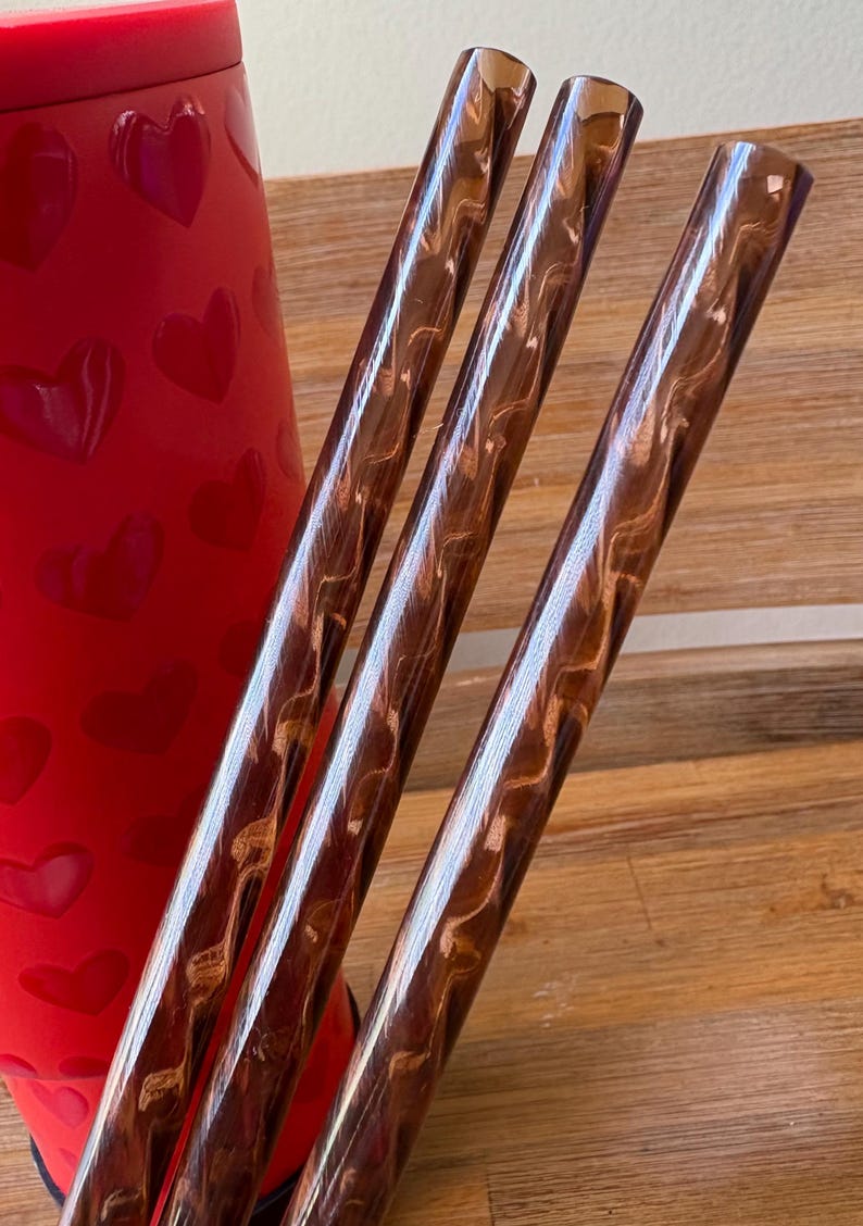 May include: Three brown and gold swirl patterned drinking straws.