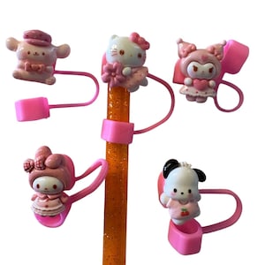 May include: Five character-themed straw toppers in pink and white. Each topper features a different cartoon character, including Hello Kitty, and is attached to a pink straw holder. The straw is orange with glitter.