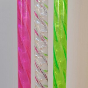 以下が含まれることがあります： ねじれたプラスチック製のストロー3本。ピンク、ピンクとグリーンの渦巻き模様のクリア、グリーンの3色です。