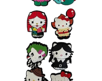 May include: A selection of colourful cartoon charms, featuring various characters. The charms include a stitched doll, a mermaid, and several Hello Kitty-inspired figures dressed as horror movie characters. These charms are likely for shoes or accessories.