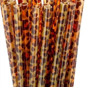 May include: A bundle of brown and tan plastic drinking straws with a leopard print design.