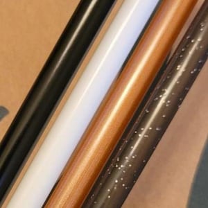 Può includere: Quattro aste cilindriche disposte in diagonale. La prima è nera tinta unita, la seconda è bianca tinta unita, la terza è di colore rame metallizzato e la quarta è in materiale marrone scuro traslucido con piccole particelle di glitter argentato.