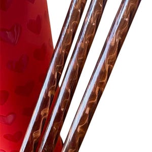 May include: Three brown and gold striped drinking straws.