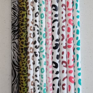 Op de afbeelding: Een set van tien kleurrijke rietjes met verschillende dierenprintontwerpen. De rietjes zijn gemaakt van helder plastic en hebben een witte achtergrond met verschillende dierenprints, waaronder zebra, luipaard, cheetah en giraffe.