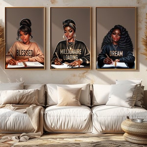 May include: Three digital art prints featuring illustrations of Black women writing in journals. The prints are framed in gold and have the words "Blessed", "Millionaire Loading", and "Dream" written on them.