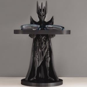 May include: Black 3D printed figurine of a dark lord holding a tray for glasses. The figurine is wearing a crown and a long robe.