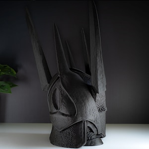 May include: A black, 3D printed crown with a textured surface and sharp points. The crown is a replica of the Iron Throne from the popular TV series Game of Thrones.