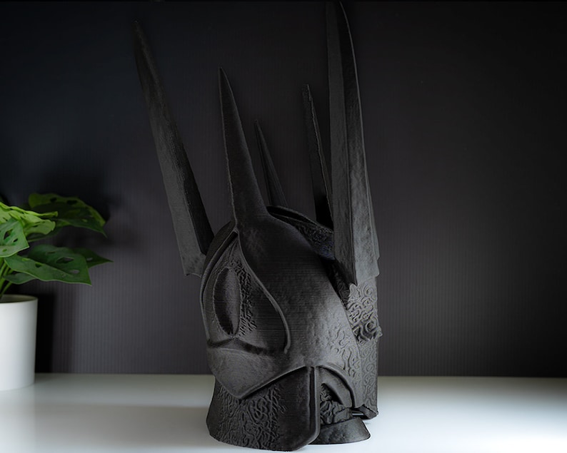 May include: A black, 3D printed crown with a textured surface and sharp points. The crown is a replica of the Iron Throne from the popular TV series Game of Thrones.