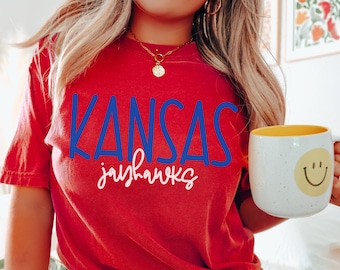 May include: Red t-shirt with the text "Kansas Jayhawks" in blue and white lettering.