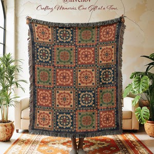 May include: A woven throw blanket with a geometric pattern in shades of red, blue, green, and beige. The blanket has a fringed edge and is displayed indoors. The text "@invenov Crafting Memories, One Gift at a Time." is visible.