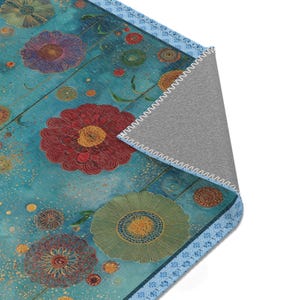 May include: A floral patterned rug with a teal background and colorful flowers in red, purple, and green. The rug has a blue border with a geometric design and a gray backing.