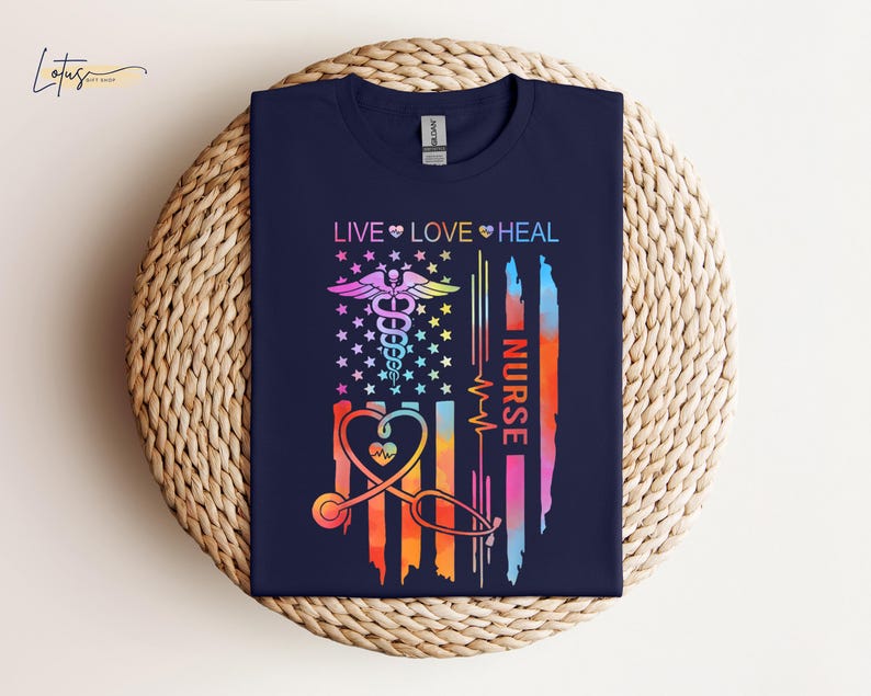 May include: A navy blue t-shirt with a rainbow-colored American flag design. The flag features a stethoscope, a heart, and the words "Live Love Heal Nurse".