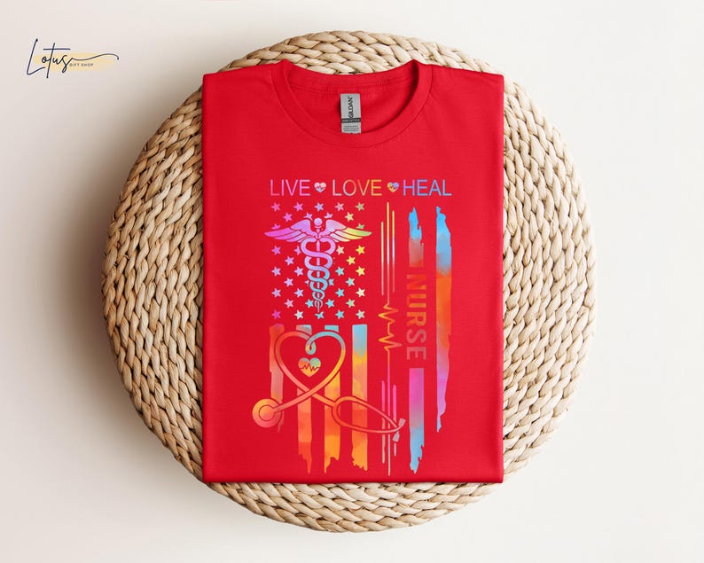 May include: Red t-shirt with a rainbow-colored American flag design. The flag features a medical caduceus symbol and the text "LIVE LOVE HEAL NURSE".