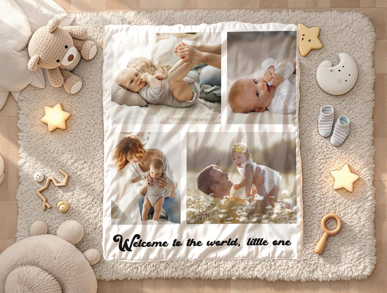 May include: A baby photo blanket with four family photos, surrounded by baby toys and accessories. The blanket has the text "Welcome to the world, little one" in black script. The toys include a teddy bear, star-shaped lights, and wooden toys.