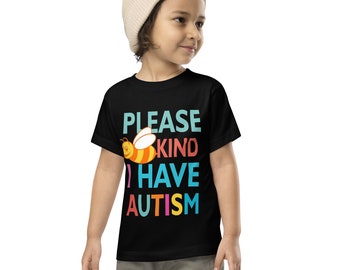 May include: Black toddler t-shirt with the text "PLEASE KIND I HAVE AUTISM" in teal, coral, blue, and yellow. A cartoon bee graphic is above the word "I". The child is wearing a beige beanie.