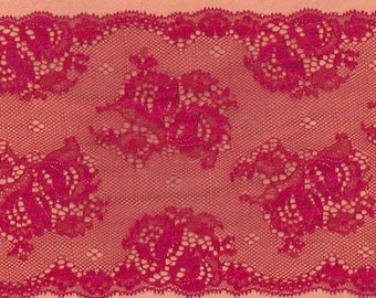 May include: Close-up of a vibrant red lace fabric. The lace features a floral pattern with detailed, openwork designs. The edges are scalloped, adding a decorative touch. The fabric is likely used for apparel or craft projects.