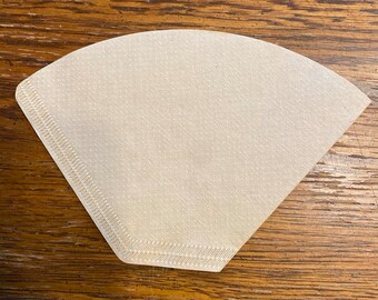 May include: A white paper coffee filter with a scalloped edge.