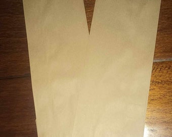 May include: Two brown paper bags on a wooden surface.