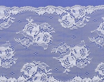 May include: White lace trim with a delicate floral pattern. The lace has a scalloped edge and is perfect for adding a touch of elegance to any project.