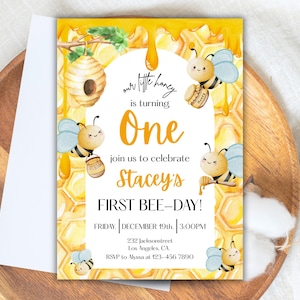 May include: A yellow and white invitation card with a bee theme. The card reads "Our little honey is turning One" and invites guests to Stacey's First Bee-Day. Includes date, time, and RSVP information.
