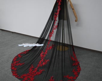 May include: A black tulle wedding veil with a red floral lace trim. The veil is long and flowing, and the lace is delicate and intricate.