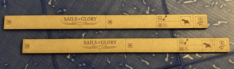 Puede incluir: Dos piezas de juego de madera marr&oacute;n para el juego de mesa "Sails of Glory: Napoleonic Wars". Cada pieza tiene una peque&ntilde;a "A" en el lado izquierdo, una "B" en el lado derecho y una serie de s&iacute;mbolos en el lado derecho.