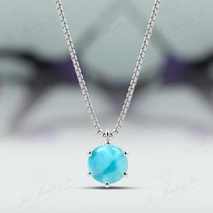 Op de afbeelding: Een zilveren ketting met een ronde blauwe edelsteen hanger. De edelsteen heeft een draaiende vorm en is gezet in een zilveren bezel.