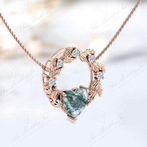 May include: A rose gold necklace with a heart-shaped green agate pendant surrounded by a delicate wreath of leaves and small diamonds.