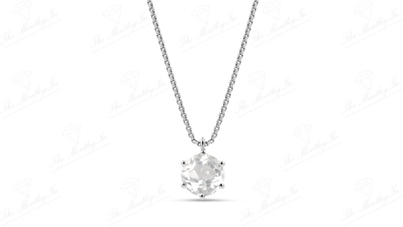 Pu&ograve; includere: Una collana d'argento con un pendente rotondo e trasparente con pietra preziosa. Il pendente &egrave; sfaccettato, catturando la luce. La catena &egrave; un design delicato e collegato. Il gioiello &egrave; su sfondo bianco.