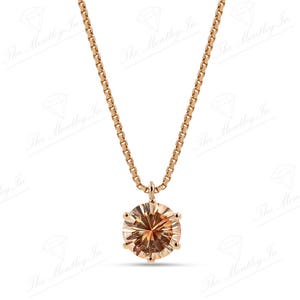 May include: A rose gold necklace featuring a round, light brown gemstone pendant. The pendant is set in a six-prong setting and hangs from a delicate chain. The necklace is displayed against a white background.