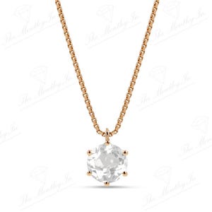 Pu&ograve; includere: Una delicata collana in oro rosa con un pendente rotondo e trasparente. Il pendente &egrave; tenuto da sei griffe e appeso a una sottile catena. La collana &egrave; mostrata su uno sfondo bianco.
