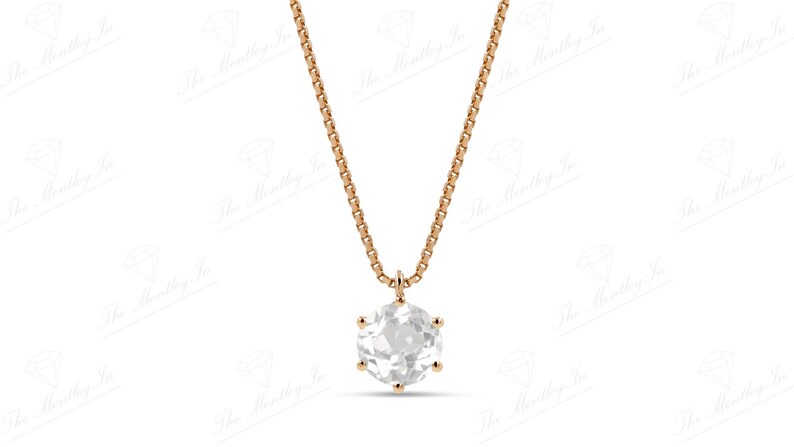 Pu&ograve; includere: Una delicata collana in oro rosa con un pendente rotondo e trasparente. Il pendente &egrave; tenuto da sei griffe e appeso a una sottile catena. La collana &egrave; mostrata su uno sfondo bianco.
