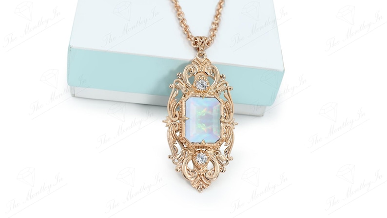 May include: A gold necklace with a large, ornate pendant featuring a rectangular iridescent stone surrounded by smaller clear stones.