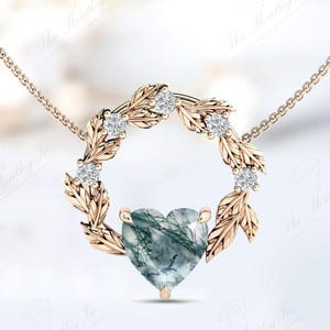 May include: A gold necklace with a heart-shaped green agate pendant surrounded by a wreath of leaves and small diamonds.